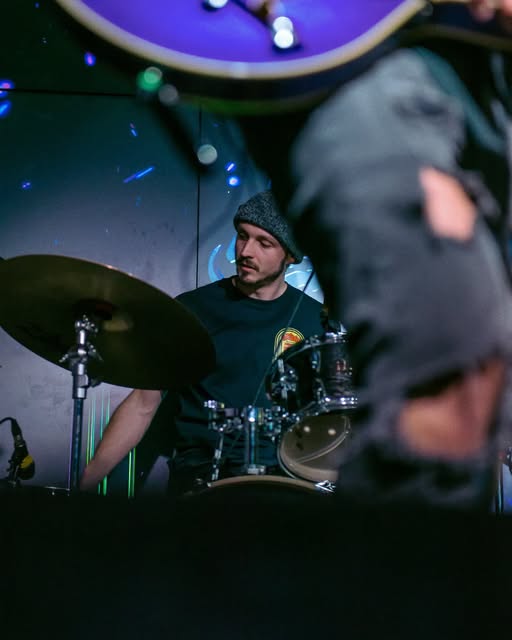 Drummer onstage behind a drum kit.